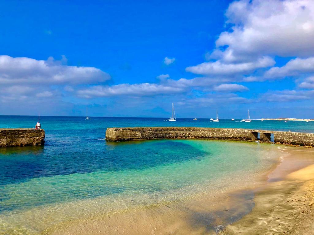 圣玛丽亚Sal&Love apt in Porto Antigo的水面上带有岩石墙的海滩