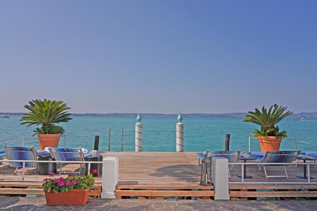西尔米奥奈马可尼酒店的水面上带椅子和植物的码头