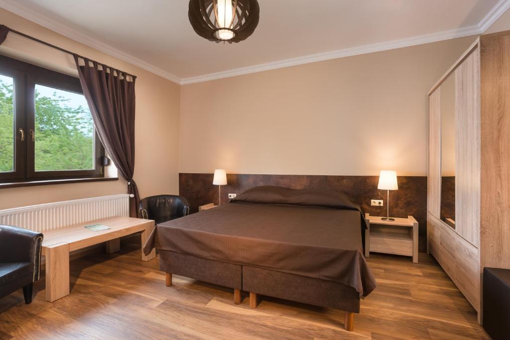 维谢格拉德Harangvirág Apartmanház - Visegrád的一间卧室配有一张床、一张桌子和一张沙发