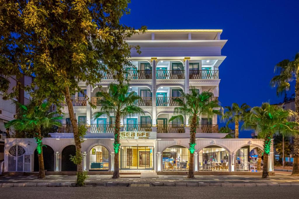 安塔利亚Sealife Lounge - Adult only的一座白色的大建筑,前面有棕榈树