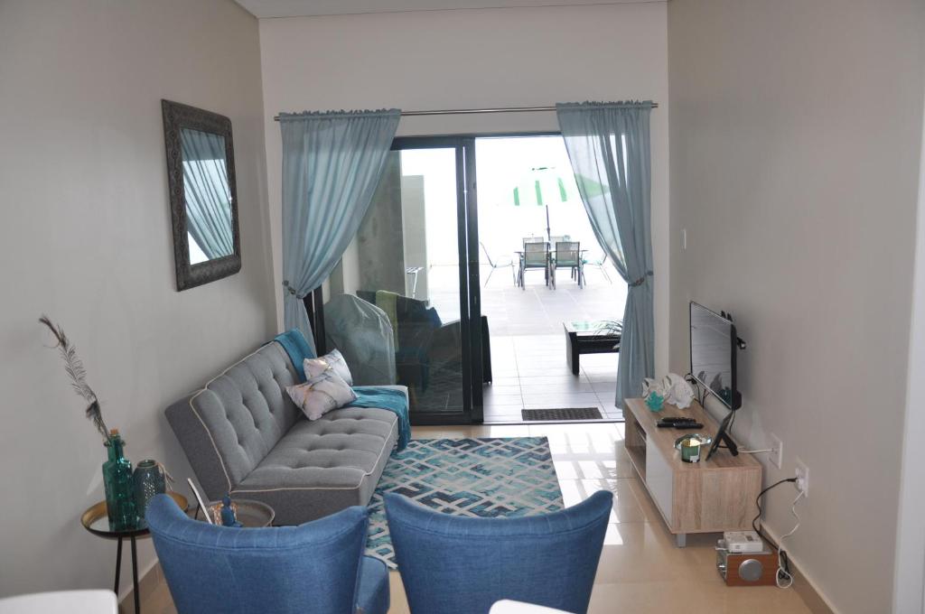 拉莫西Azure Luxury Apartments Estate的客厅配有沙发和蓝色椅子