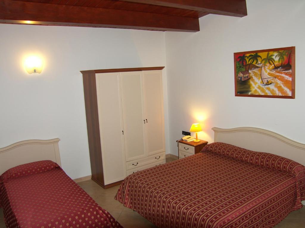 科拉托奇才酒店的一间卧室配有两张床、一个橱柜和镜子