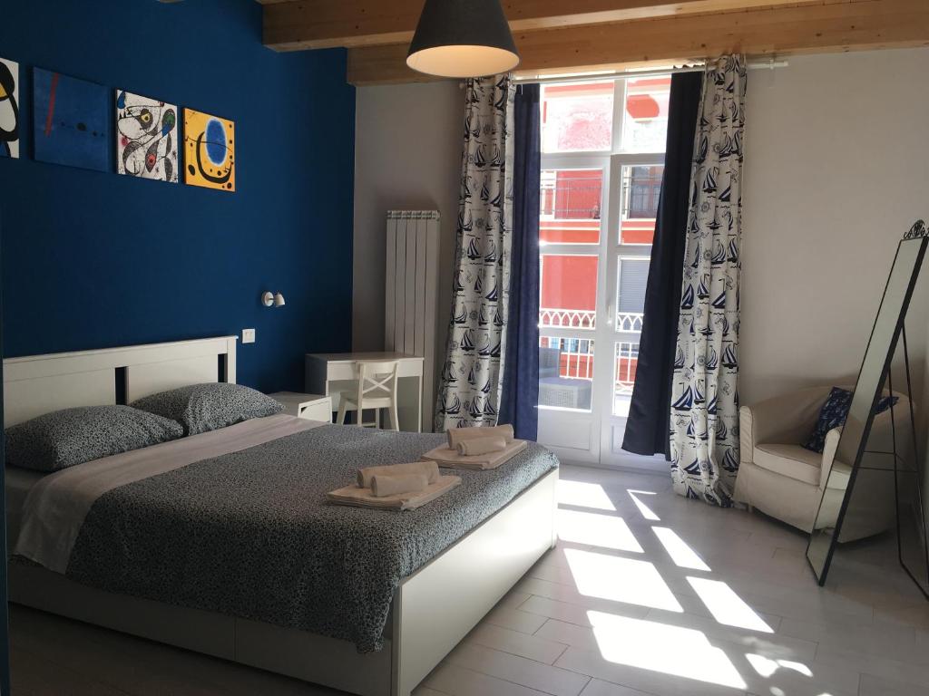 坎波巴索Sagittabondo的一间拥有蓝色墙壁的卧室、一张床和窗户