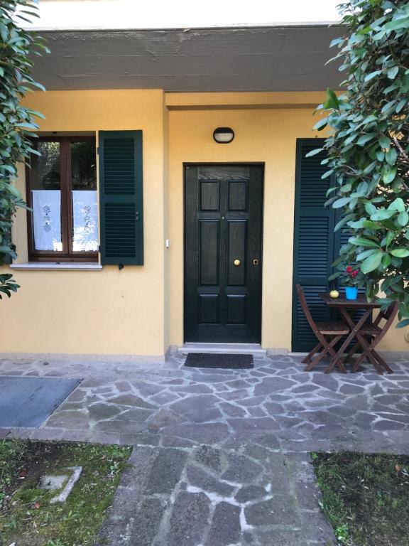 塔武利亚Casa Riccardo的黄色的房子,有黑色的门和长凳