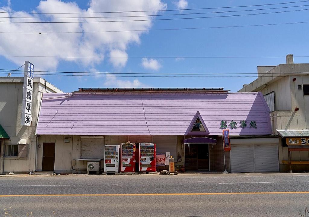 洲本市Minshuku Atsuhama的街道边有紫色屋顶的建筑