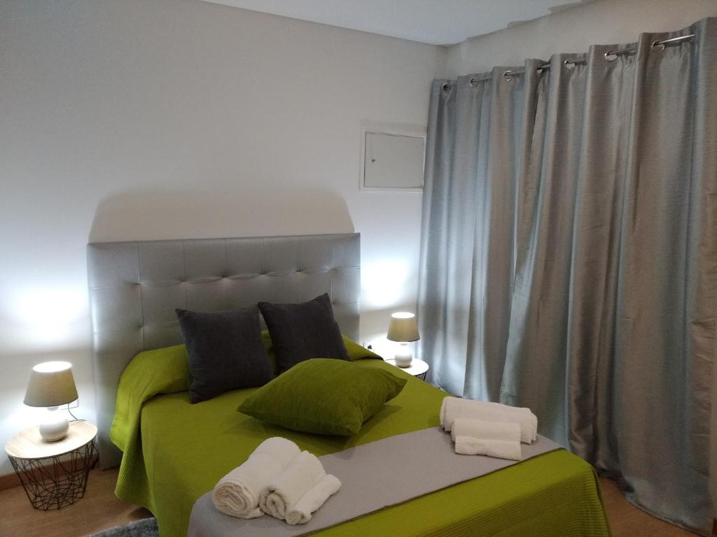 圣玛尔塔迪佩纳吉昂Casa Do Boteco的一间卧室配有绿床和毛巾