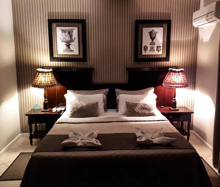 巴拉奈里奥-坎布里乌Villa Germânia的一间卧室配有一张带两张桌子和两盏灯的床。