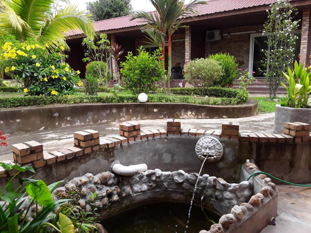 瓜拉大汉巴莱塞拉玛旅馆的一座花园,房子前方有一个喷泉