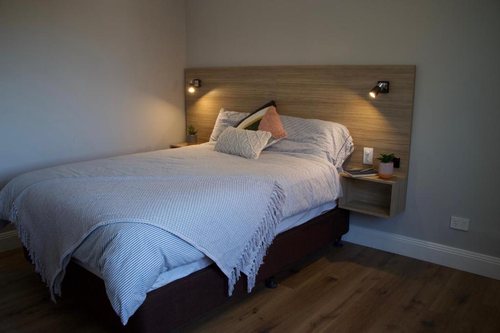 悉尼Carnarvon Lodge Kirribilli, Sydney的一间卧室配有一张大床和木制床头板