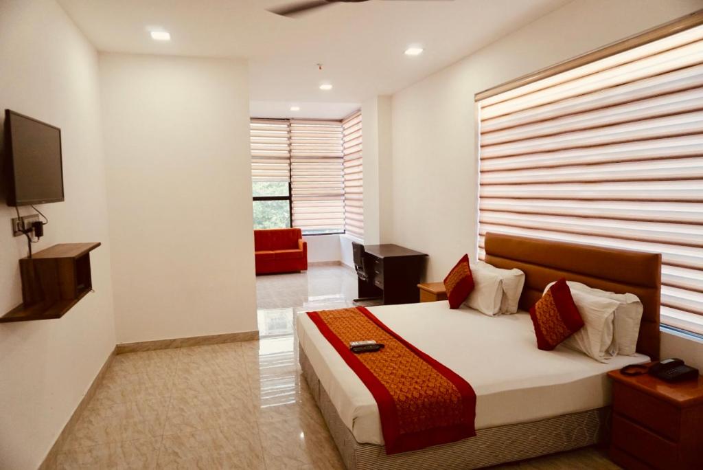 新德里Amora Rooms Dwarka的一间卧室设有一张大床和大窗户