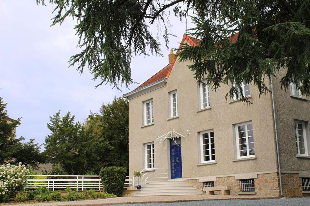 莱瑟佩瑟La Maison du Parc的一座带蓝色门和楼梯的大房子