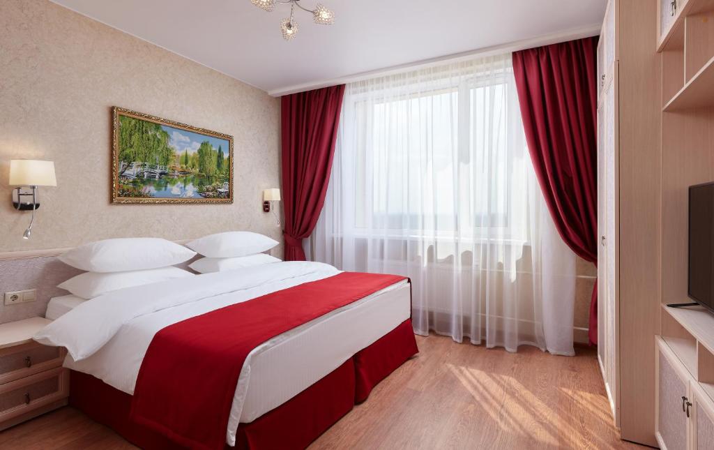 莫斯科河内-莫斯科公寓式酒店的一间卧室配有一张带红色窗帘的大床