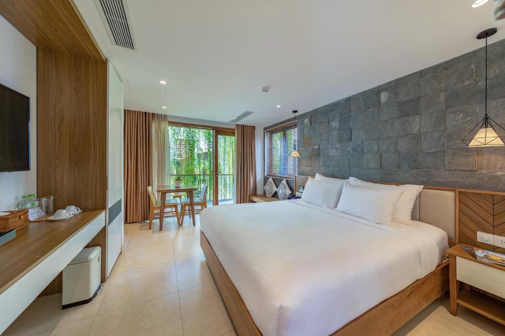 岘港Ponte Boutique Da Nang的卧室配有一张白色的大床和一张桌子