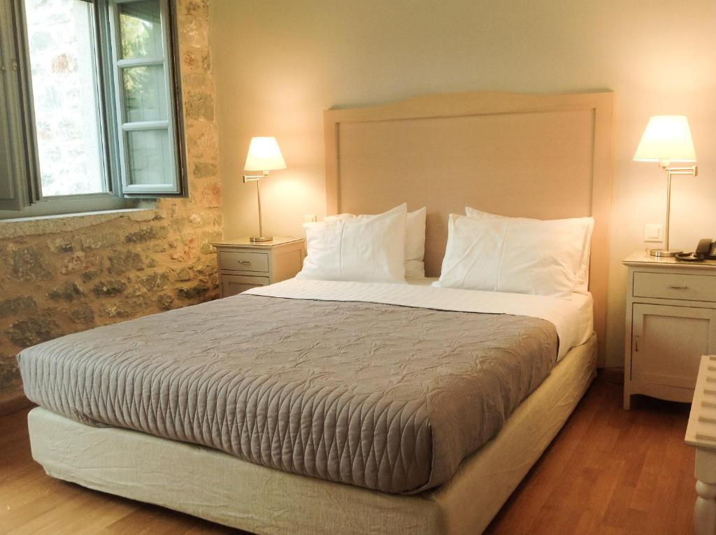 伊西翁提瑞迪斯比奇酒店的一间卧室配有一张大床、两张桌子和两盏灯。