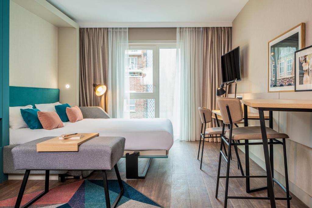 里尔Aparthotel Adagio Lille Centre Grand Place的配有一张床和一张书桌的酒店客房