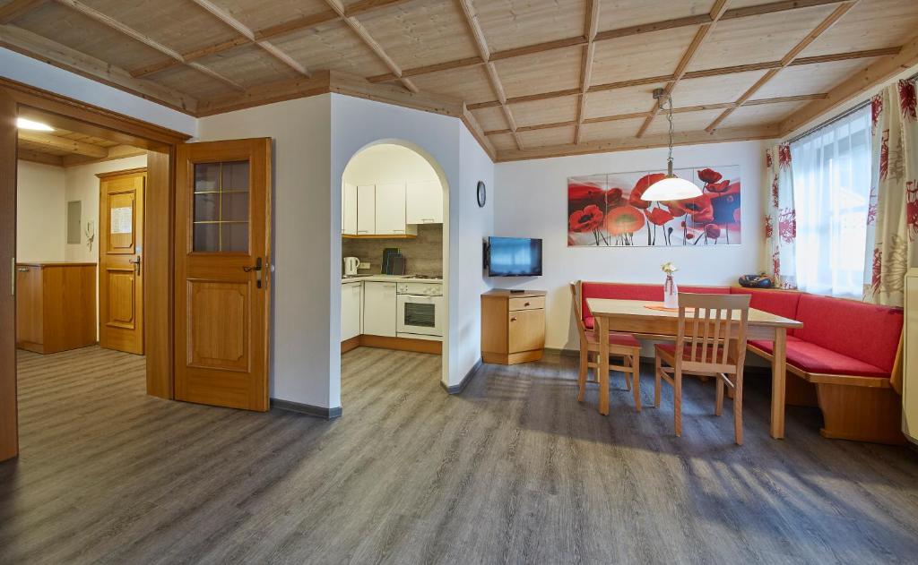萨尔巴赫Appartements Living Saalbach的客厅配有桌子和红色沙发