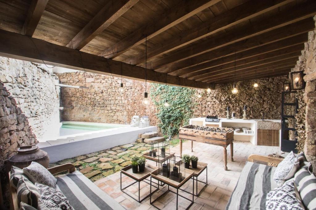 摩拉鲁比罗Valencia Luxury - Mora de Rubielos con Piscina的室外客厅设有石墙和浴缸。