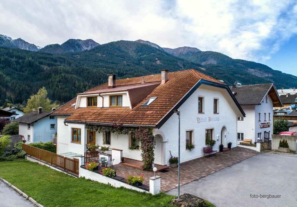 锡利安Haus Arnold - Privatzimmer und Ferienwohnungen的一座大白色房子,后面是群山