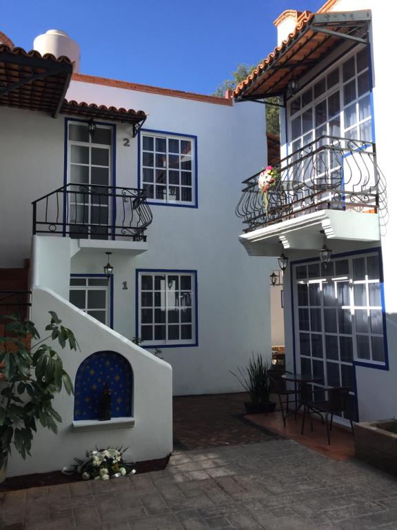 圣胡安特奥蒂瓦坎Villa Las Campanas的白色的房子设有两个阳台和庭院