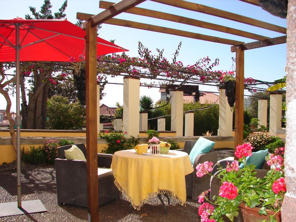 丰沙尔Purple Studio的一个带桌子和红色遮阳伞的庭院