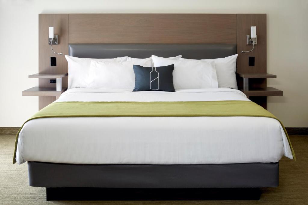 Beloeil Village莱芙高什酒店的卧室配有带白色枕头的大床