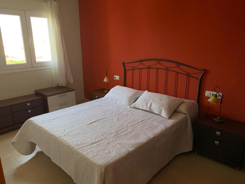 阿尔梅利马Apartamentos San Miguel 2的卧室配有白色大床和橙色墙壁