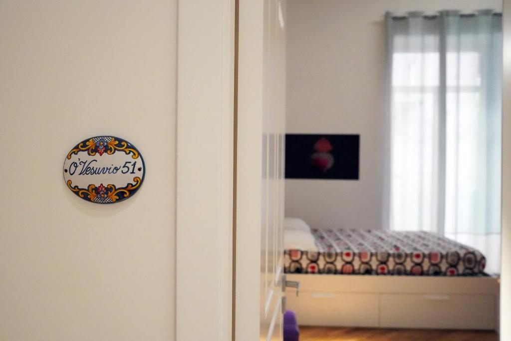 那不勒斯Magia di Napoli的卧室配有一张床,墙上挂着一个钟