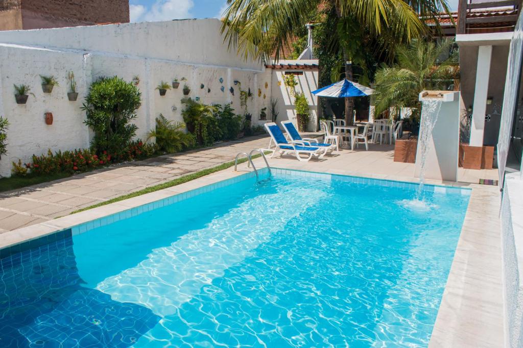 马塞约赛雷亚酒店的一个带椅子和桌子的蓝色游泳池