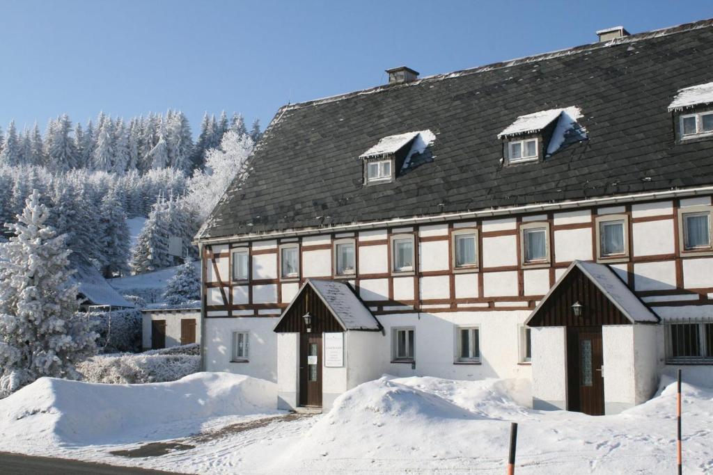 库罗阿尔滕堡Ferienhaus Am Skihang的前面有雪的大建筑