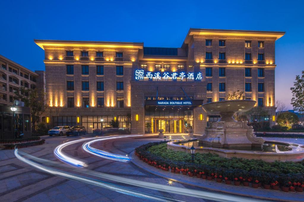 杭州杭州西溪谷君亭酒店的一座建筑前面有喷泉