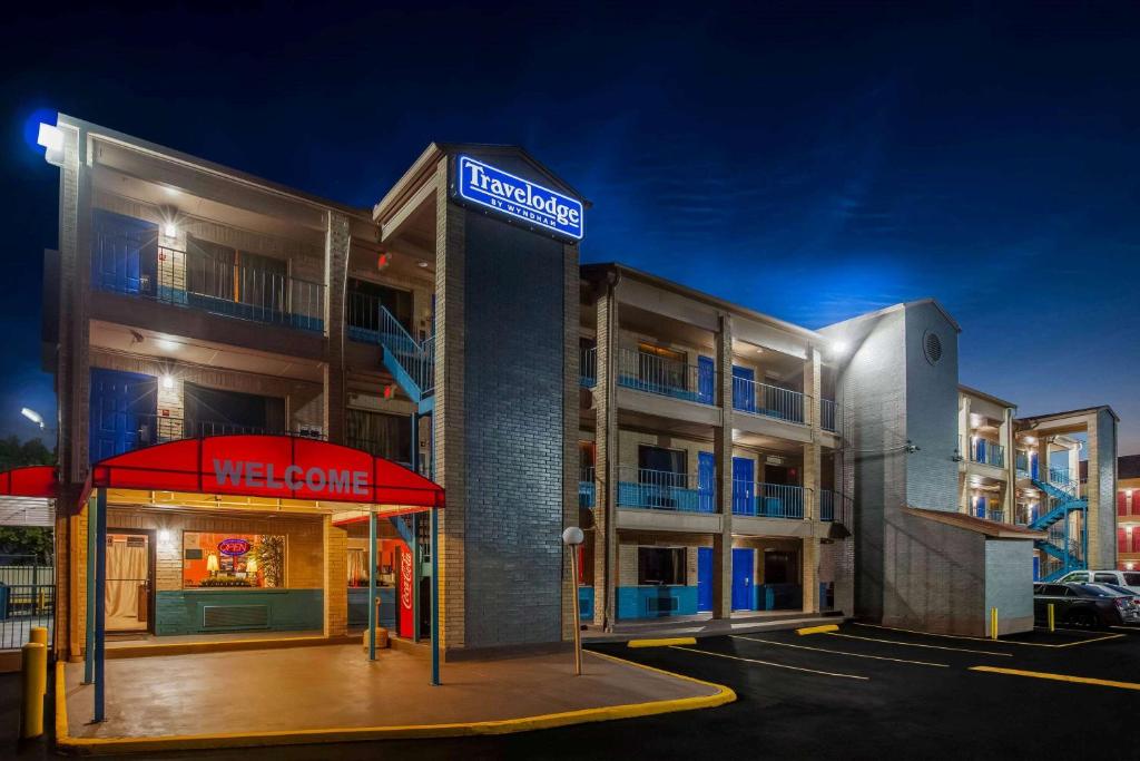 休斯顿Travelodge by Wyndham Houston Hobby Airport的停车场内有迎宾标志的酒店