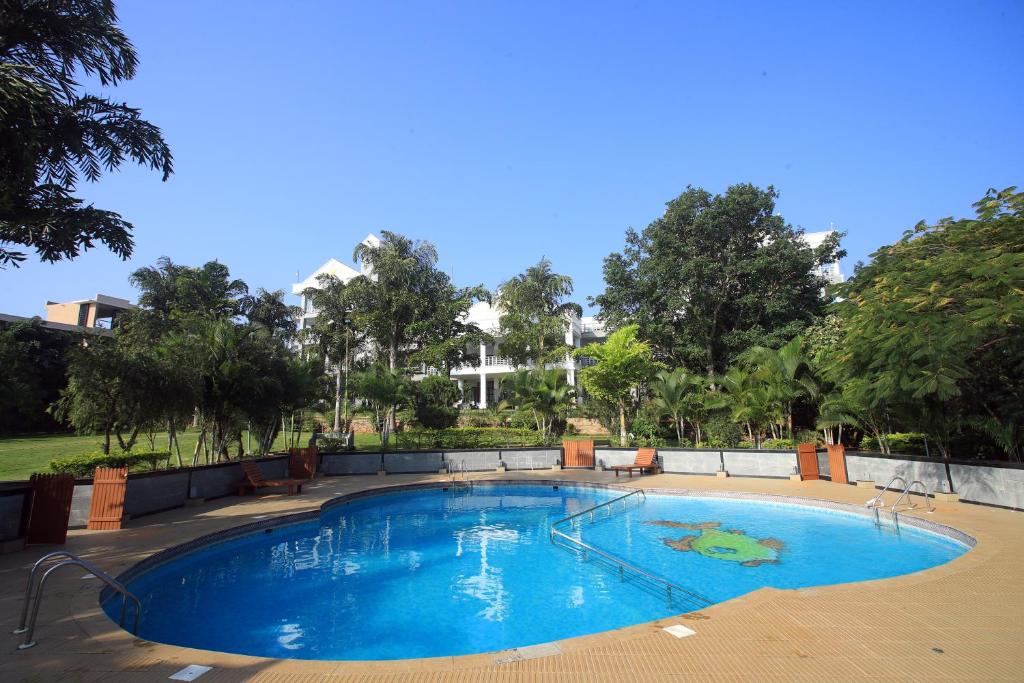 DenkanikottaiHoliday Valley Hotels And Resorts的一个种有树木的大型蓝色游泳池