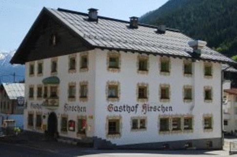 卡普尔Gasthof Hirschen的黑色屋顶的白色大建筑