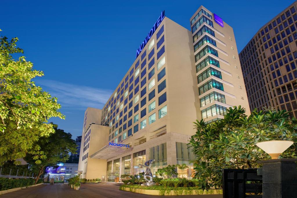 艾哈迈达巴德Novotel Ahmedabad的前面有树木的高楼