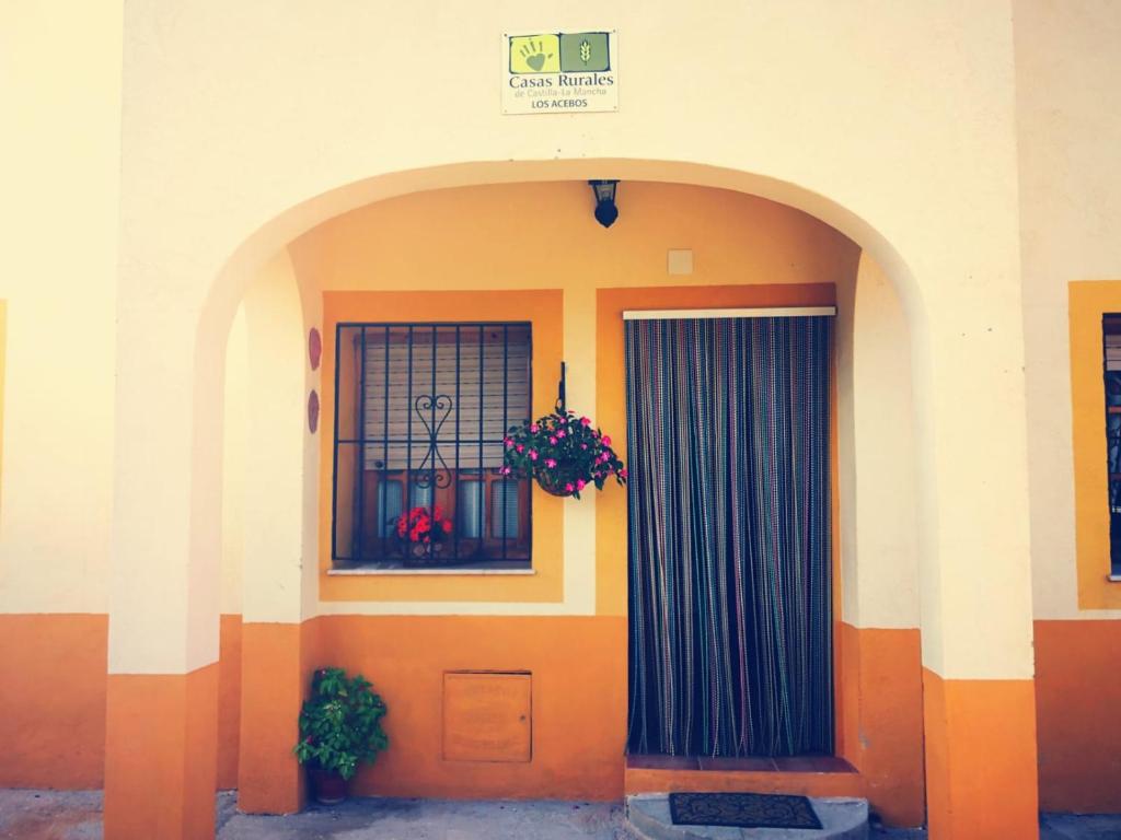 里奥帕尔Casa Rural Los Acebos的一座带门和鲜花窗户的建筑