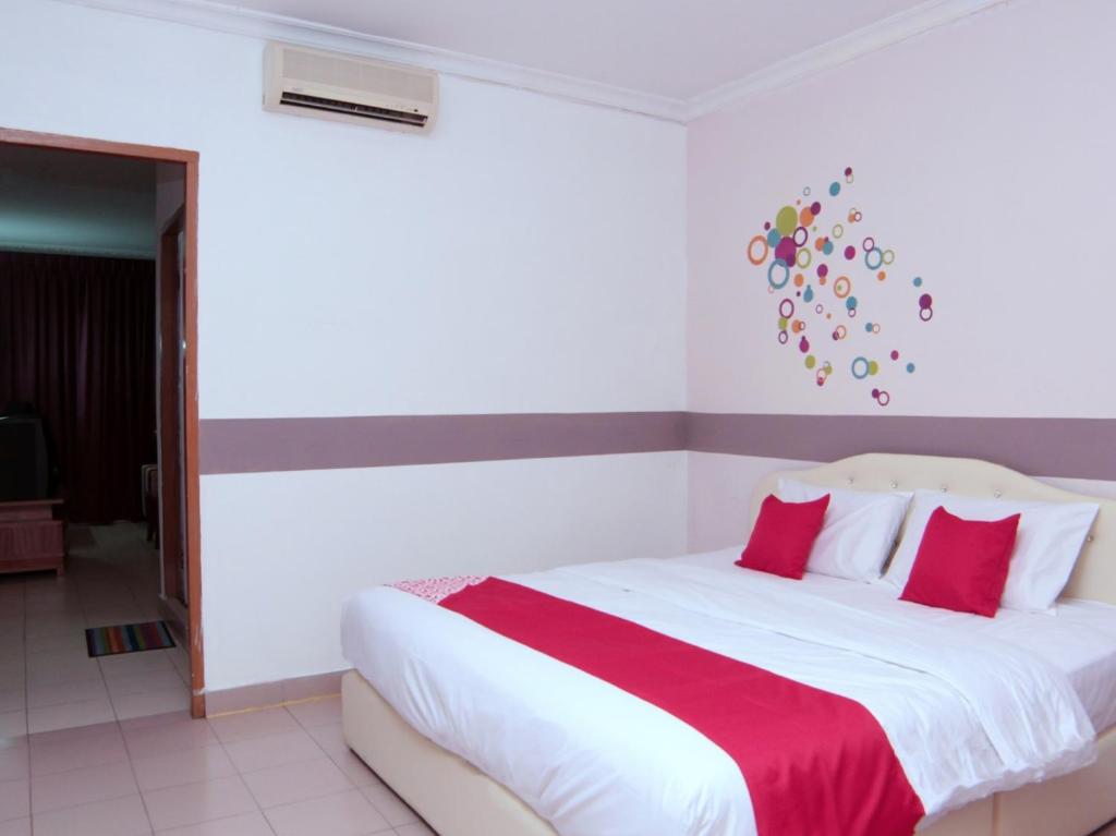 诗巫OYO 1173 Mandyrin Hotel的卧室配有带红色枕头的大型白色床