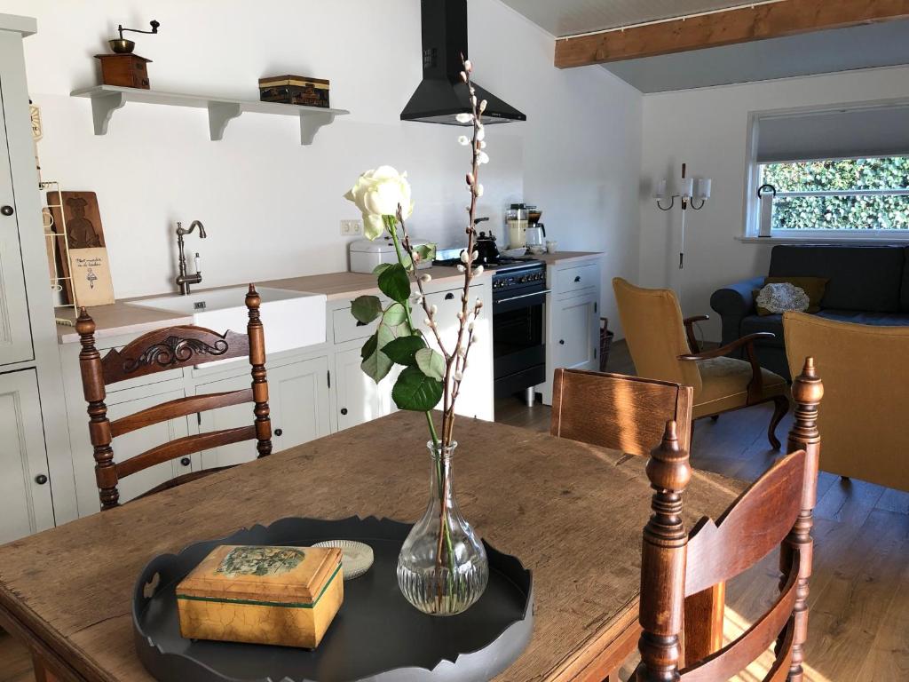 SilvoldeHalte Bontebrug的厨房以及带花瓶的桌子的用餐室