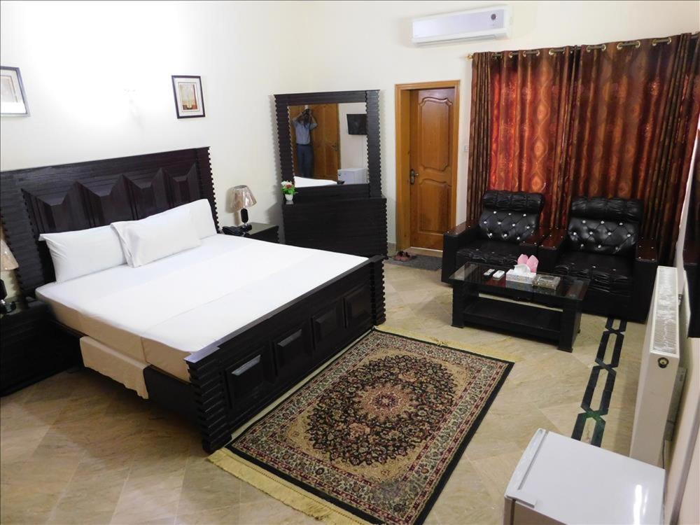 伊斯兰堡Melberry House的一间卧室配有一张大床和地毯。