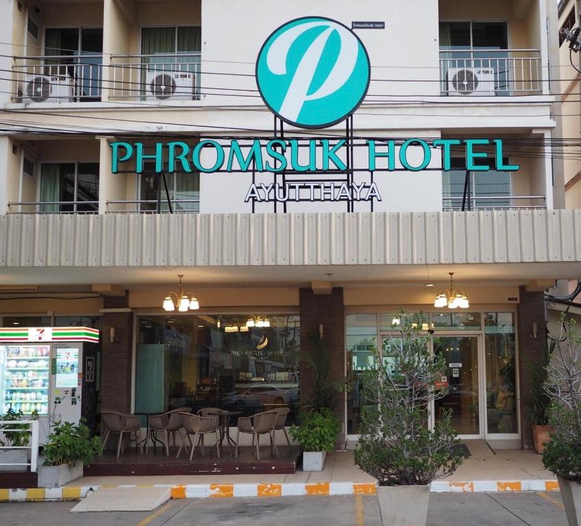大城Phromsuk Hotel Ayutthaya的大楼前的凤凰酒店标志