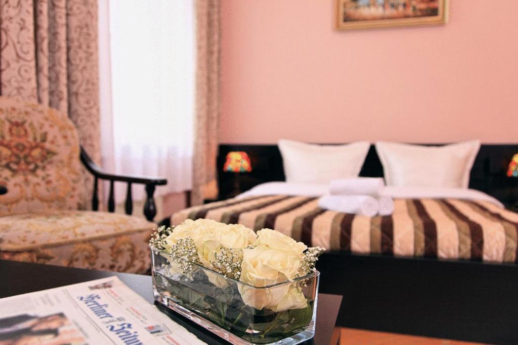 柏林考提纳旅馆酒店的配有床和鲜花桌的酒店客房