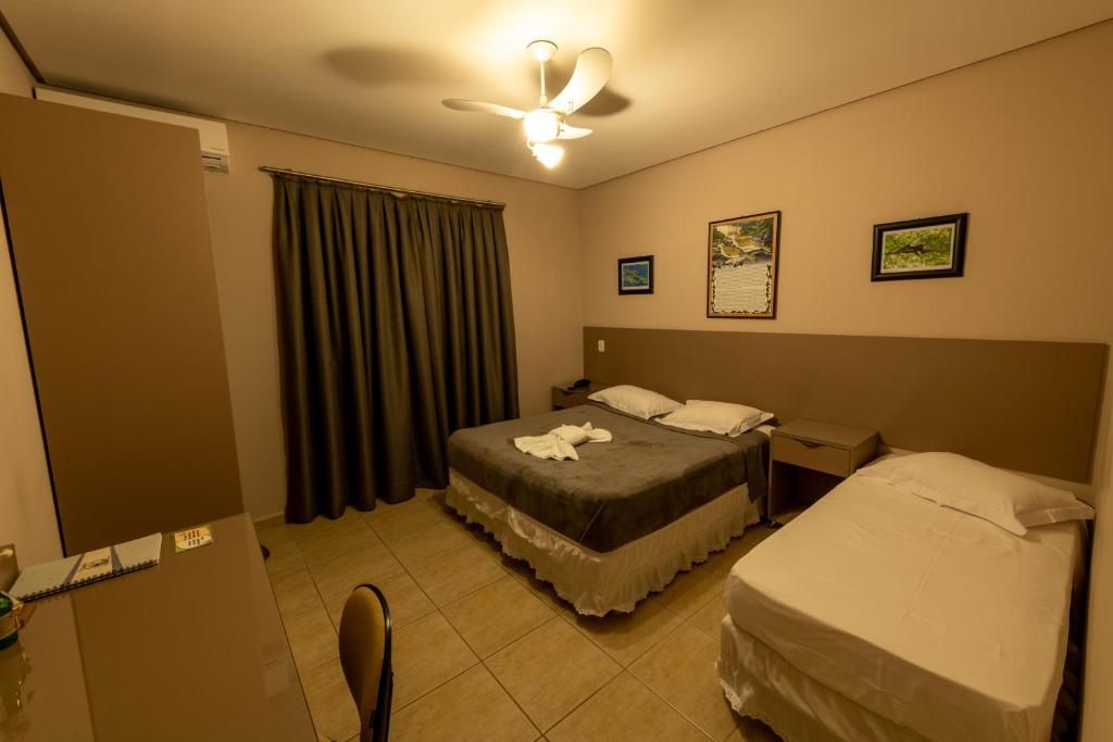圣米格尔-阿尔坎茹Pousada Villa da Mata的酒店客房配有两张床和吊扇。