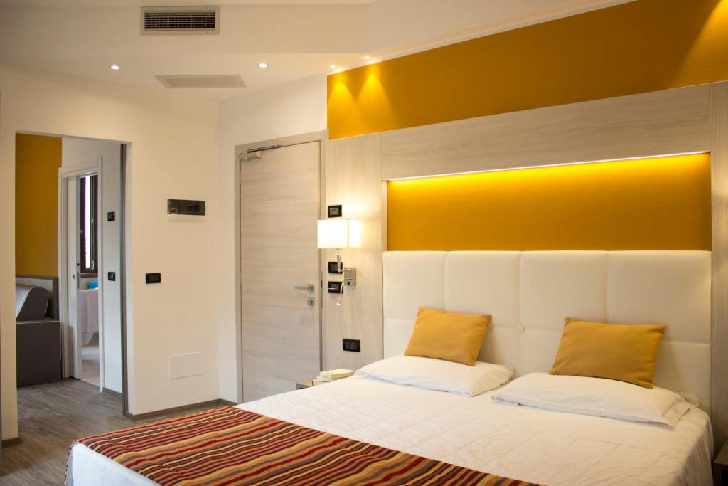 马尔切西内多罗米堤酒店的一间卧室配有一张带黄色床头板的大床