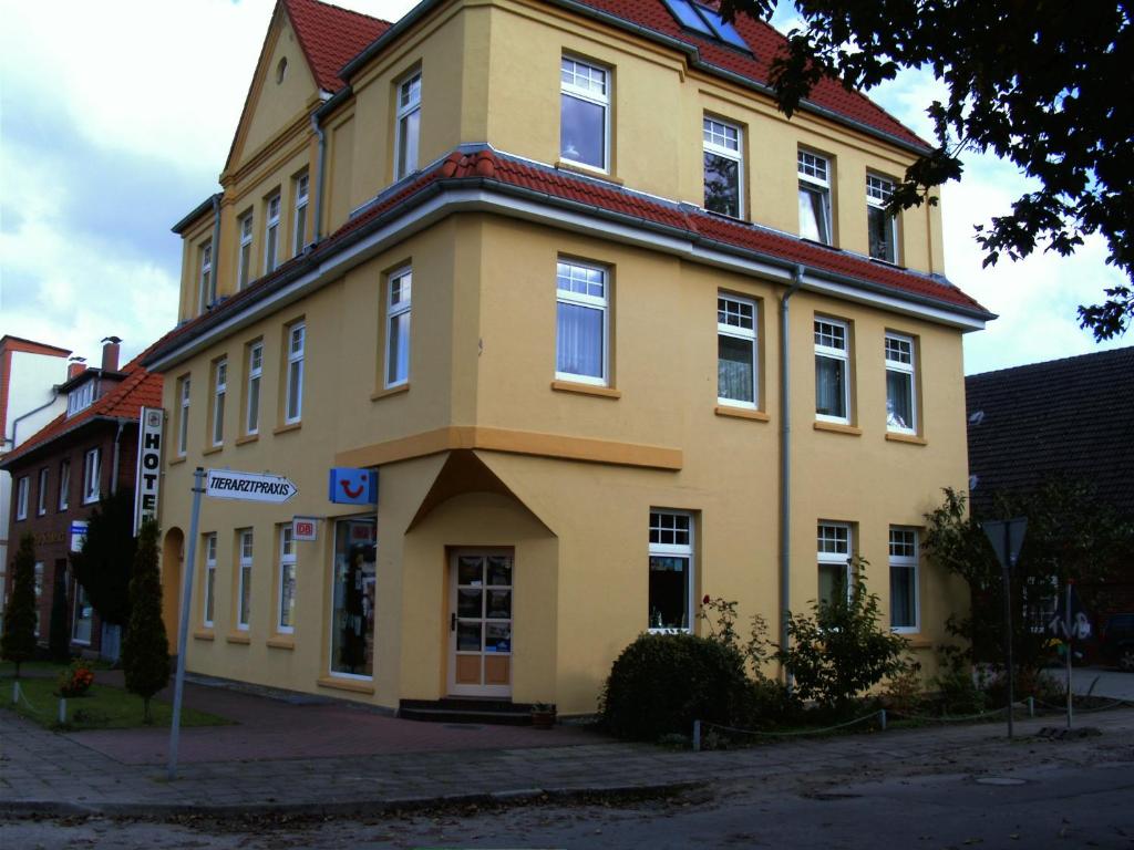 博伊岑堡Hotel Boizenburger Hof的红色屋顶的大型黄色建筑
