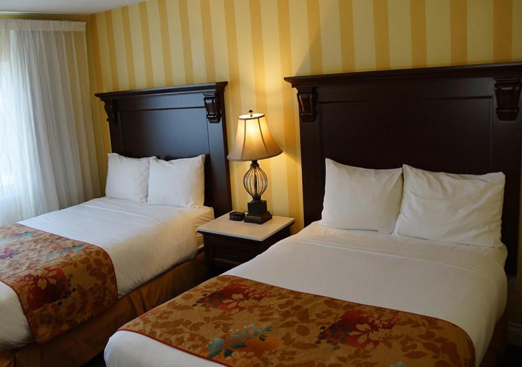 维多利亚阿布特斯旅馆的酒店客房,设有两张床和一盏灯
