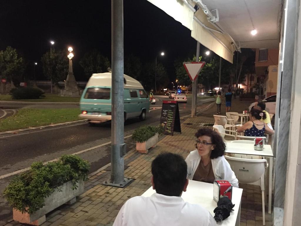 莫特里尔Hostal Puerto Beach的两个人晚上坐在街上的桌子上