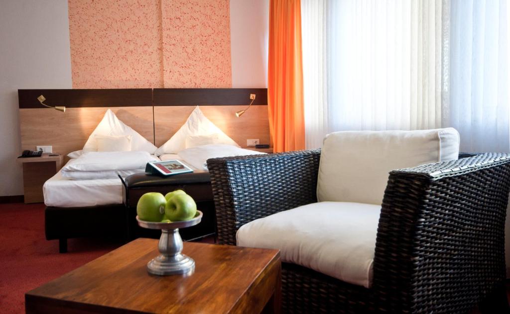杜塞尔多夫Hotel Cascade Superior的酒店客房配有床、沙发和桌子。