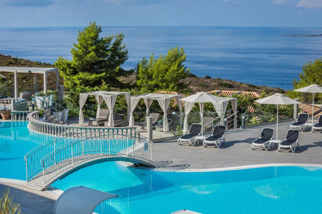 拉瑟狄奥尼索斯度假公寓的一座带桥梁和椅子的游泳池