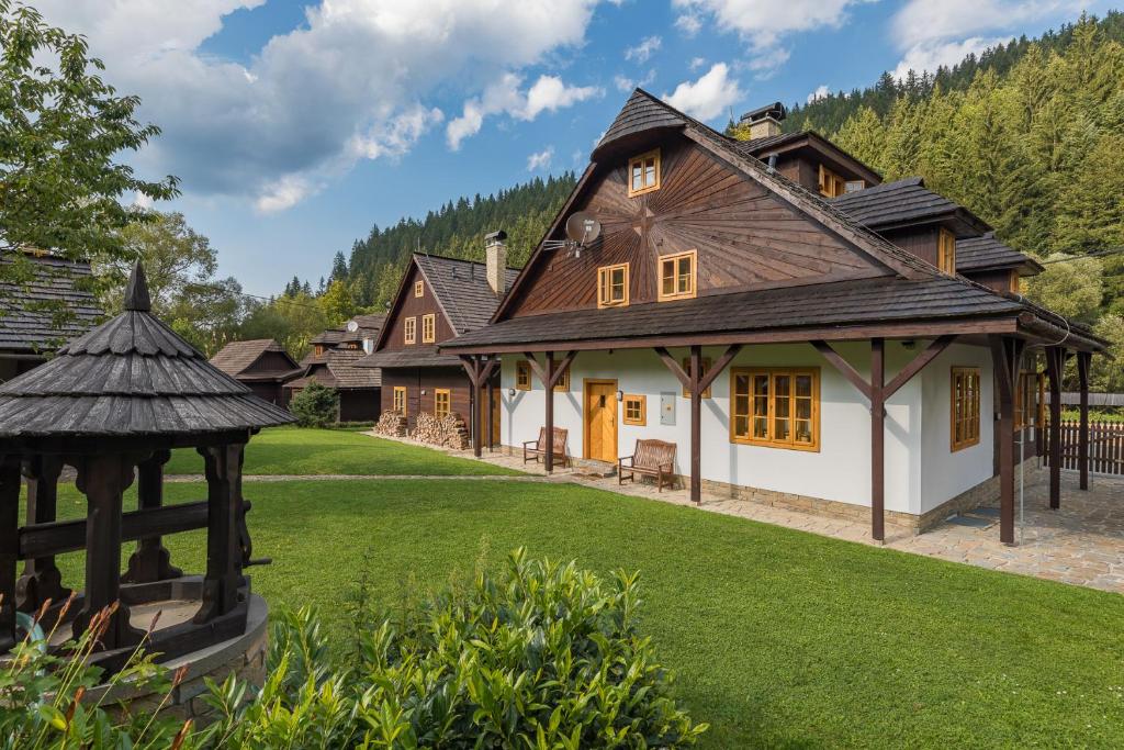 大卡尔洛维采Valašské chalupy Resort的一座房子,设有一座带凉亭的大院子
