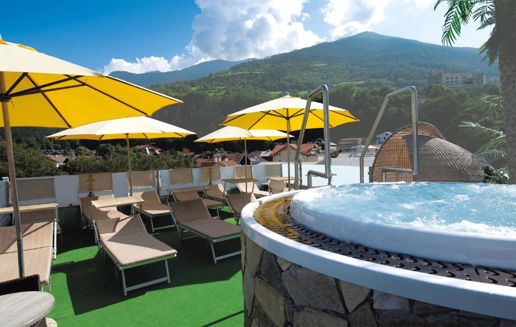斯卢德尔诺安格尔酒店的度假村内带椅子和遮阳伞的热水浴池