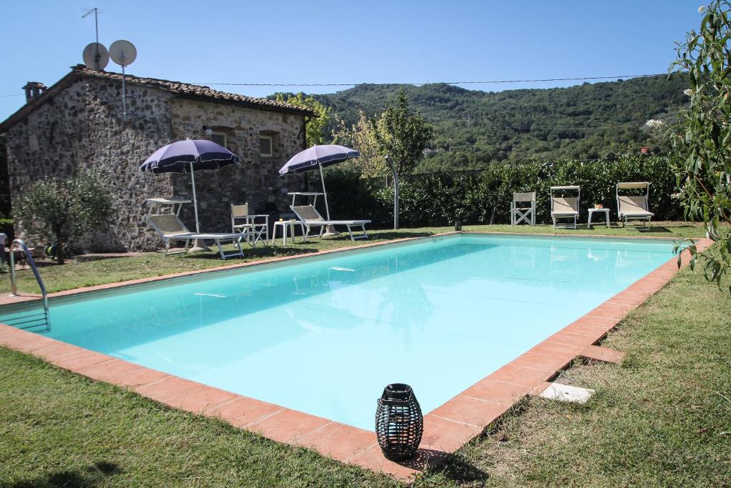 博尔戈阿莫扎诺Casa Patrizia的一个带椅子和遮阳伞的大型蓝色游泳池